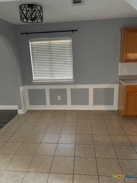 unfurnished dining area with light tile patterned flooring