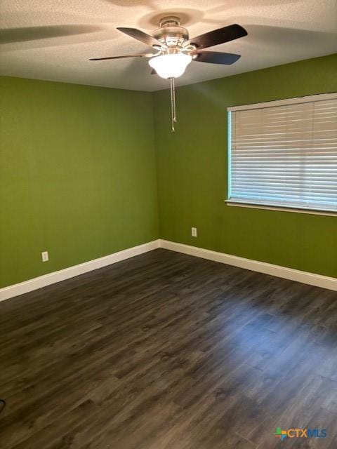 spare room with a textured ceiling, dark hardwood / wood-style floors, and ceiling fan