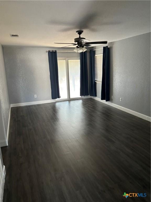 empty room featuring ceiling fan and dark wood-type flooring