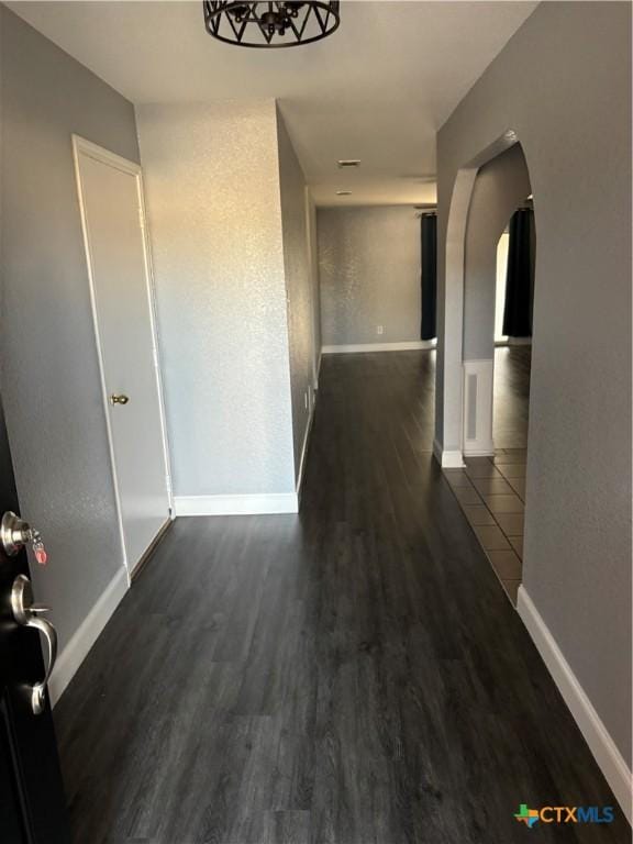 corridor with dark hardwood / wood-style flooring