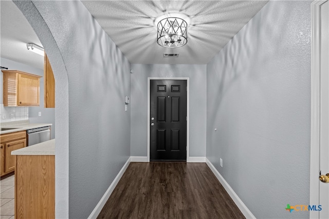 entryway with dark hardwood / wood-style flooring, a textured ceiling, and sink