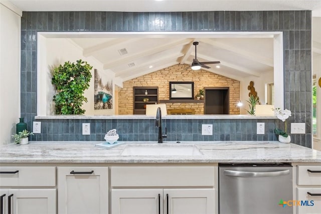 interior space featuring stainless steel dishwasher, a ceiling fan, a sink, and vaulted ceiling with beams