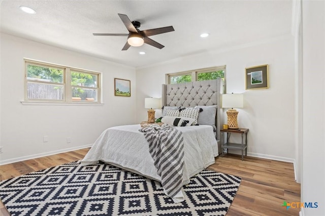 bedroom featuring crown molding, wood finished floors, ceiling fan, baseboards, and recessed lighting