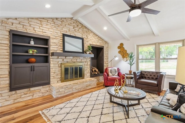 living room featuring a glass covered fireplace, wood finished floors, vaulted ceiling with beams, and ceiling fan