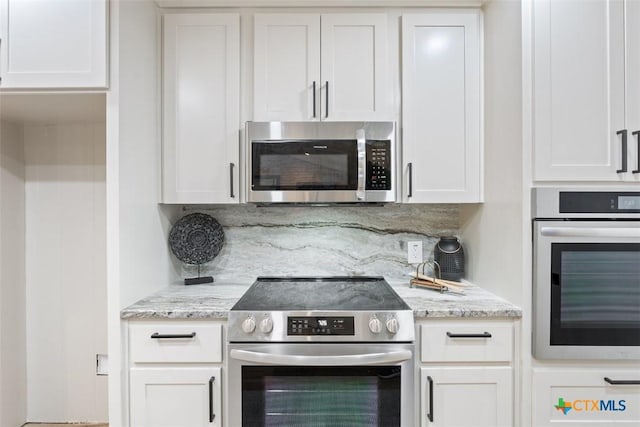 kitchen featuring tasteful backsplash, white cabinetry, light stone countertops, and stainless steel appliances