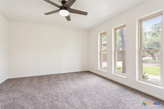 empty room featuring a ceiling fan, baseboards, and carpet