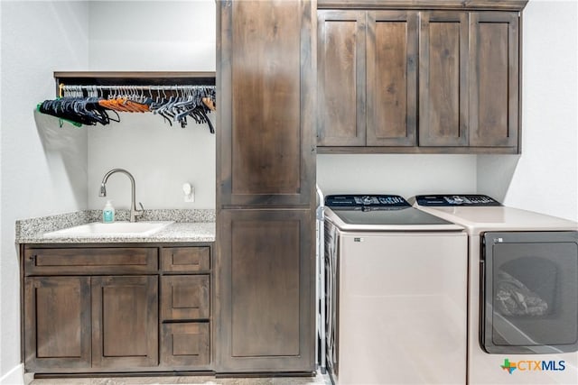 laundry area with cabinets, independent washer and dryer, and sink