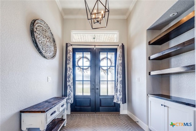 entryway with a notable chandelier, crown molding, and french doors