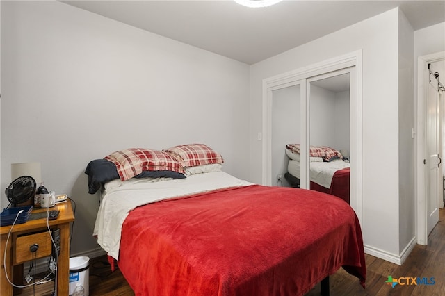 bedroom featuring dark wood-type flooring and a closet