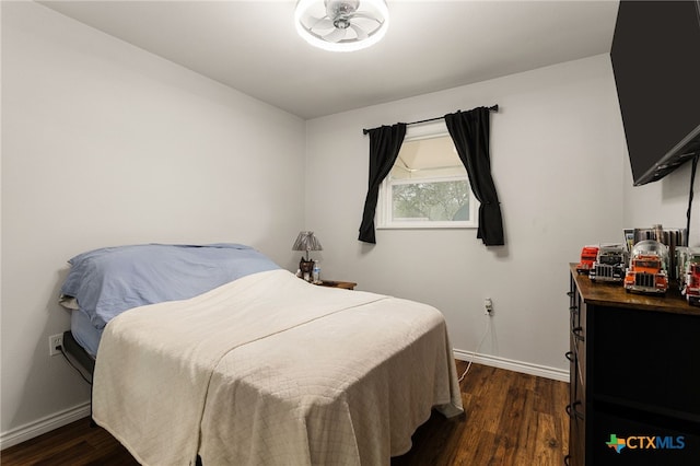 bedroom with dark hardwood / wood-style floors