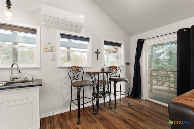 dining space with lofted ceiling, a wall mounted air conditioner, dark hardwood / wood-style flooring, and sink