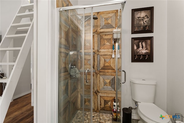 bathroom with an enclosed shower, hardwood / wood-style flooring, and toilet