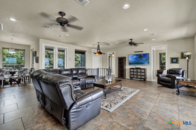 living room with a textured ceiling and ceiling fan