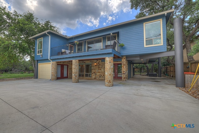 view of front of property with a garage, a carport, and a balcony