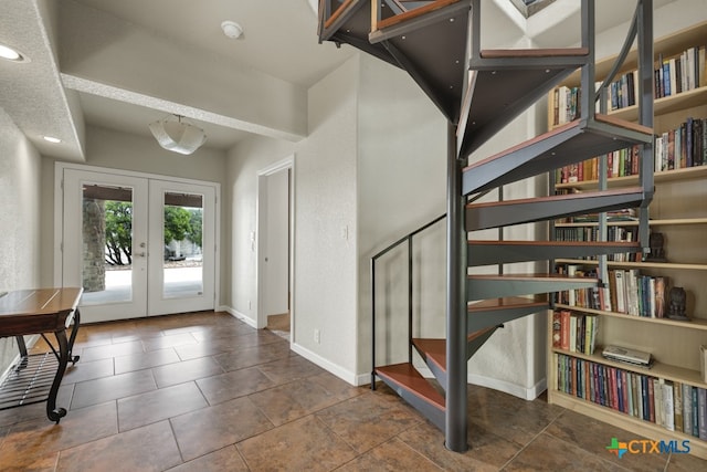 entryway featuring dark tile patterned floors and french doors