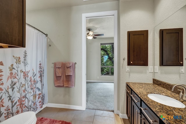 bathroom with tile patterned flooring, ceiling fan, a textured ceiling, vanity, and toilet