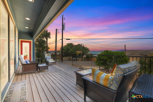 deck at dusk featuring an outdoor hangout area