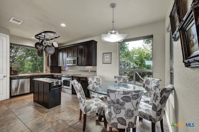 dining space with sink and an inviting chandelier