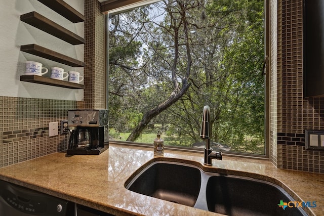 kitchen featuring dishwashing machine, sink, and tasteful backsplash