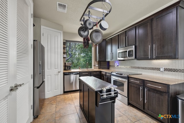 kitchen featuring a center island, dark brown cabinetry, and stainless steel appliances