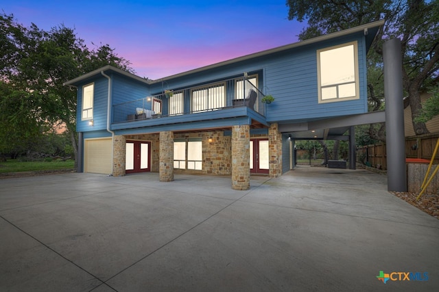 view of front of house with a garage, a carport, and a balcony