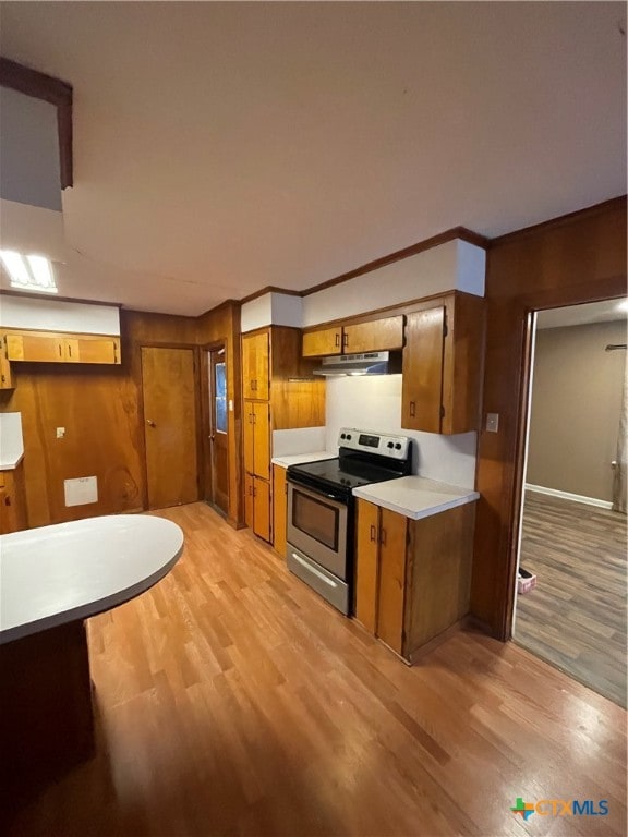 kitchen with stainless steel electric range oven, light wood-type flooring, and crown molding