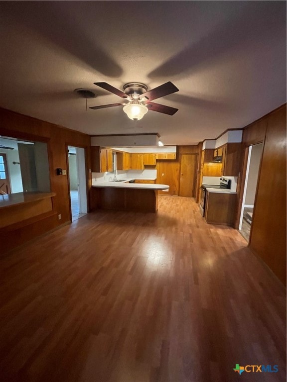 kitchen with light hardwood / wood-style floors, sink, kitchen peninsula, ceiling fan, and white electric stove