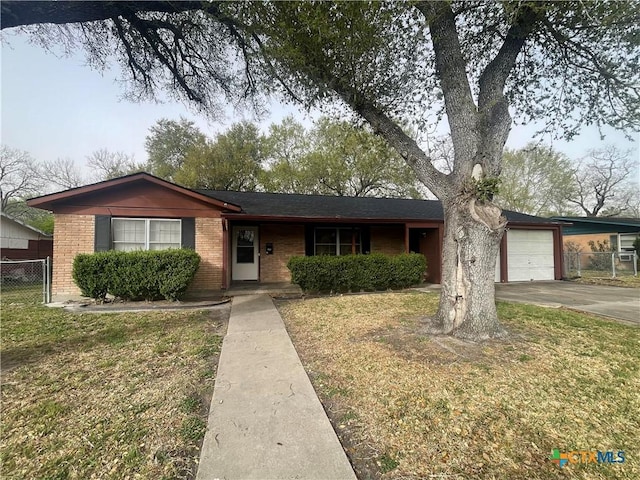 single story home with fence, an attached garage, a front lawn, concrete driveway, and brick siding