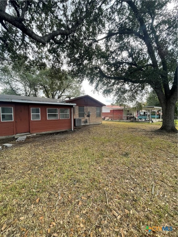 exterior space with cooling unit and a yard