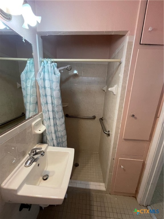 bathroom featuring walk in shower, sink, and tile patterned floors