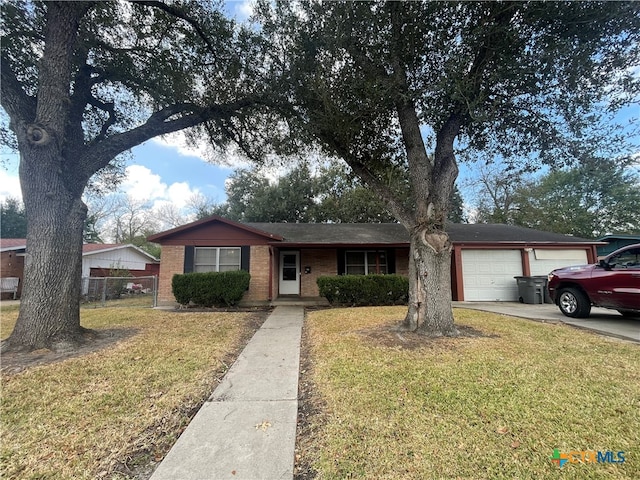 ranch-style house with an attached garage, brick siding, fence, concrete driveway, and a front yard