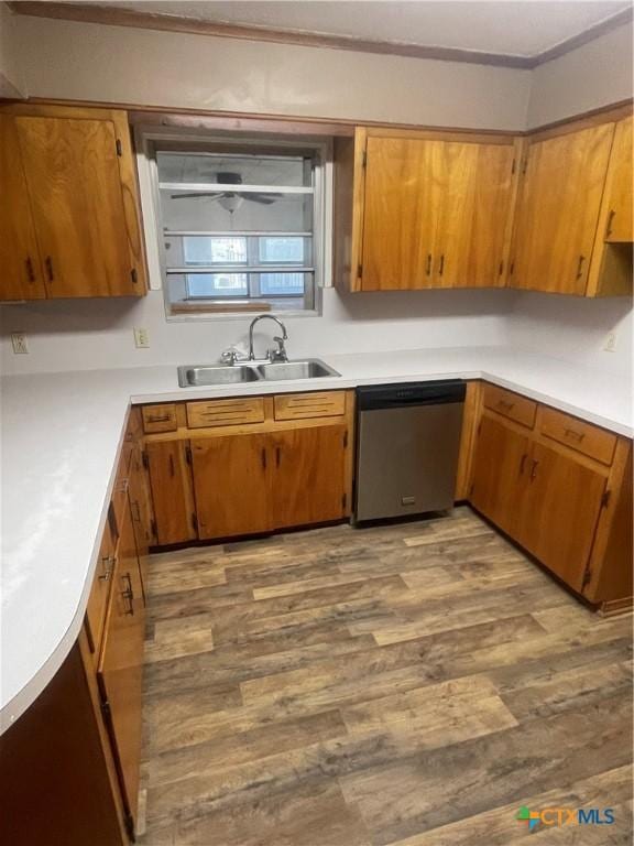 kitchen featuring dark wood finished floors, ornamental molding, a sink, light countertops, and dishwasher
