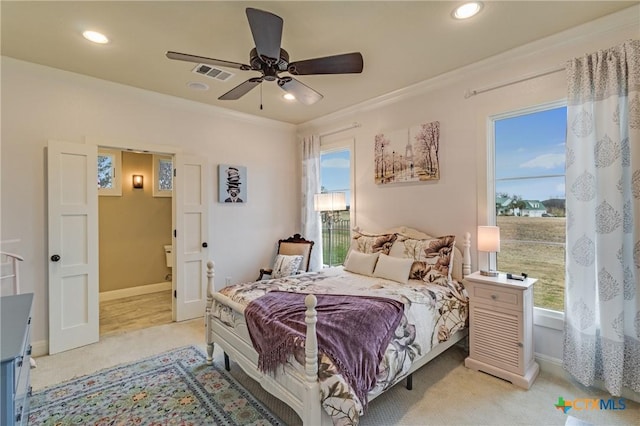 carpeted bedroom with ornamental molding, ceiling fan, and ensuite bathroom