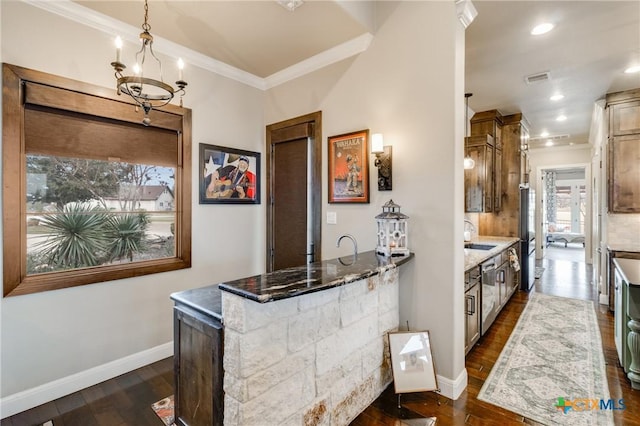 kitchen with crown molding, refrigerator, dark stone countertops, dark hardwood / wood-style floors, and pendant lighting