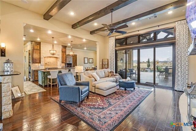 living room featuring beam ceiling, dark wood-type flooring, built in features, and a fireplace