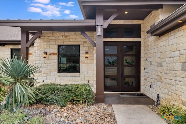 property entrance with stone siding and french doors