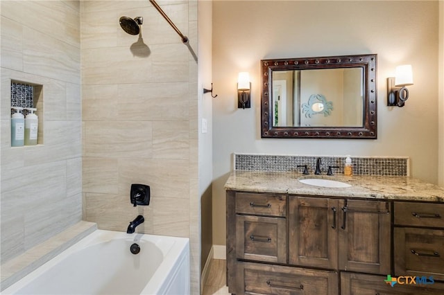 bathroom featuring vanity and tiled shower / bath