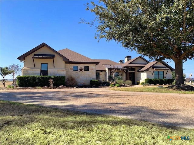 view of front facade featuring stone siding and stucco siding