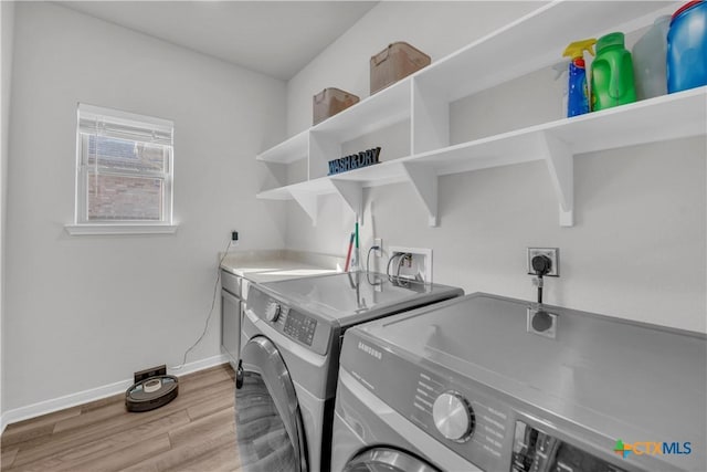 clothes washing area featuring washer and dryer and light hardwood / wood-style flooring