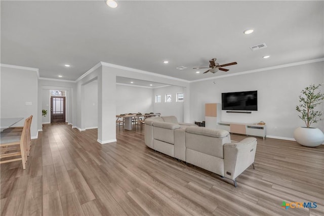 living room featuring ornamental molding, ceiling fan, and light hardwood / wood-style flooring