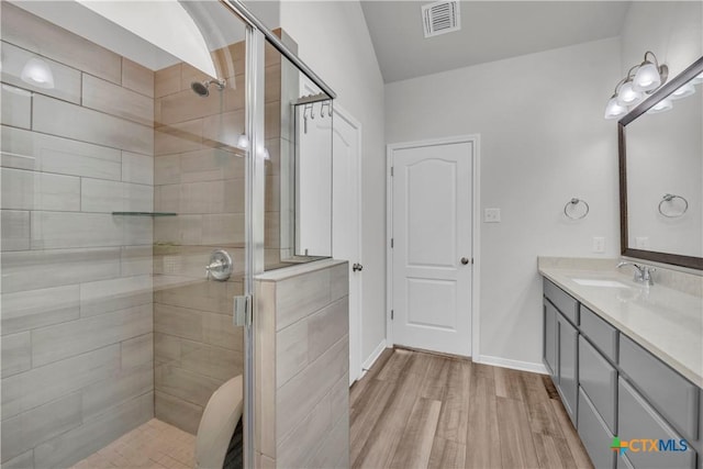 bathroom featuring hardwood / wood-style flooring, an enclosed shower, and vanity