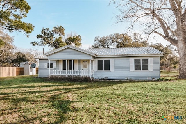 single story home featuring covered porch, metal roof, a front lawn, and fence