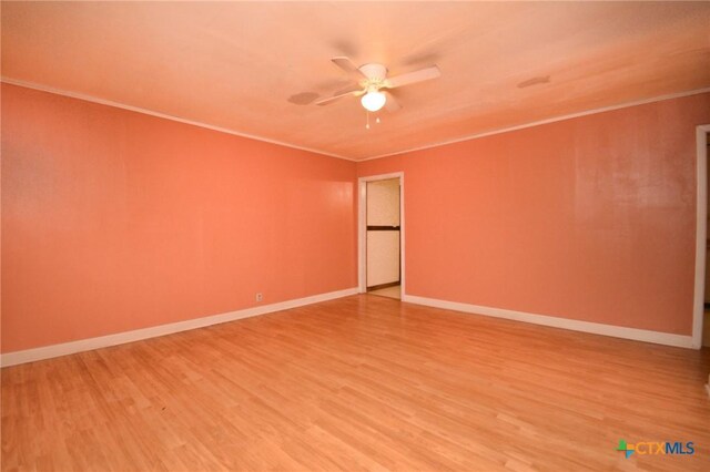 empty room featuring light wood finished floors, baseboards, crown molding, and ceiling fan