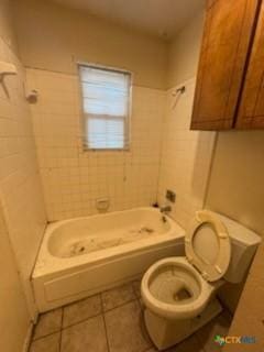 bathroom with tiled shower / bath combo, toilet, and tile patterned flooring