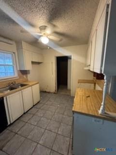 kitchen with ceiling fan, sink, white cabinetry, and a textured ceiling