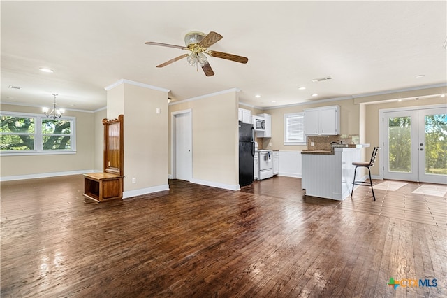 unfurnished living room featuring dark wood-type flooring, plenty of natural light, french doors, and crown molding