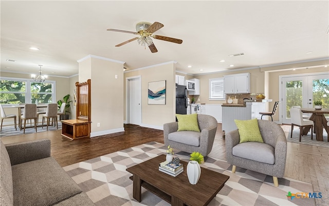 living room featuring ornamental molding, ceiling fan with notable chandelier, plenty of natural light, and light hardwood / wood-style floors