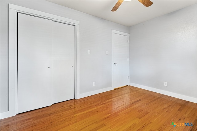 unfurnished bedroom featuring ceiling fan, wood-type flooring, and a closet