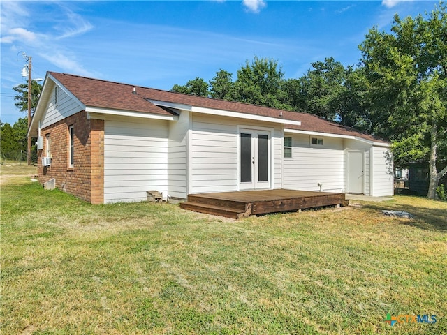 back of house featuring a deck, a lawn, and french doors