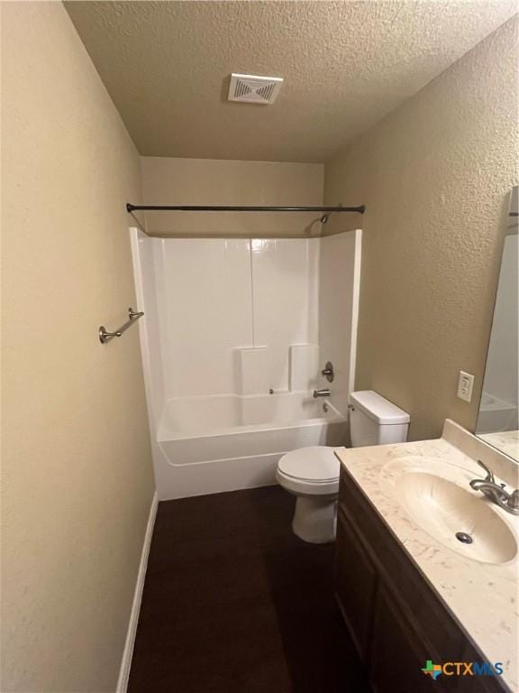 full bathroom featuring visible vents, toilet, shower / tub combination, a textured ceiling, and vanity